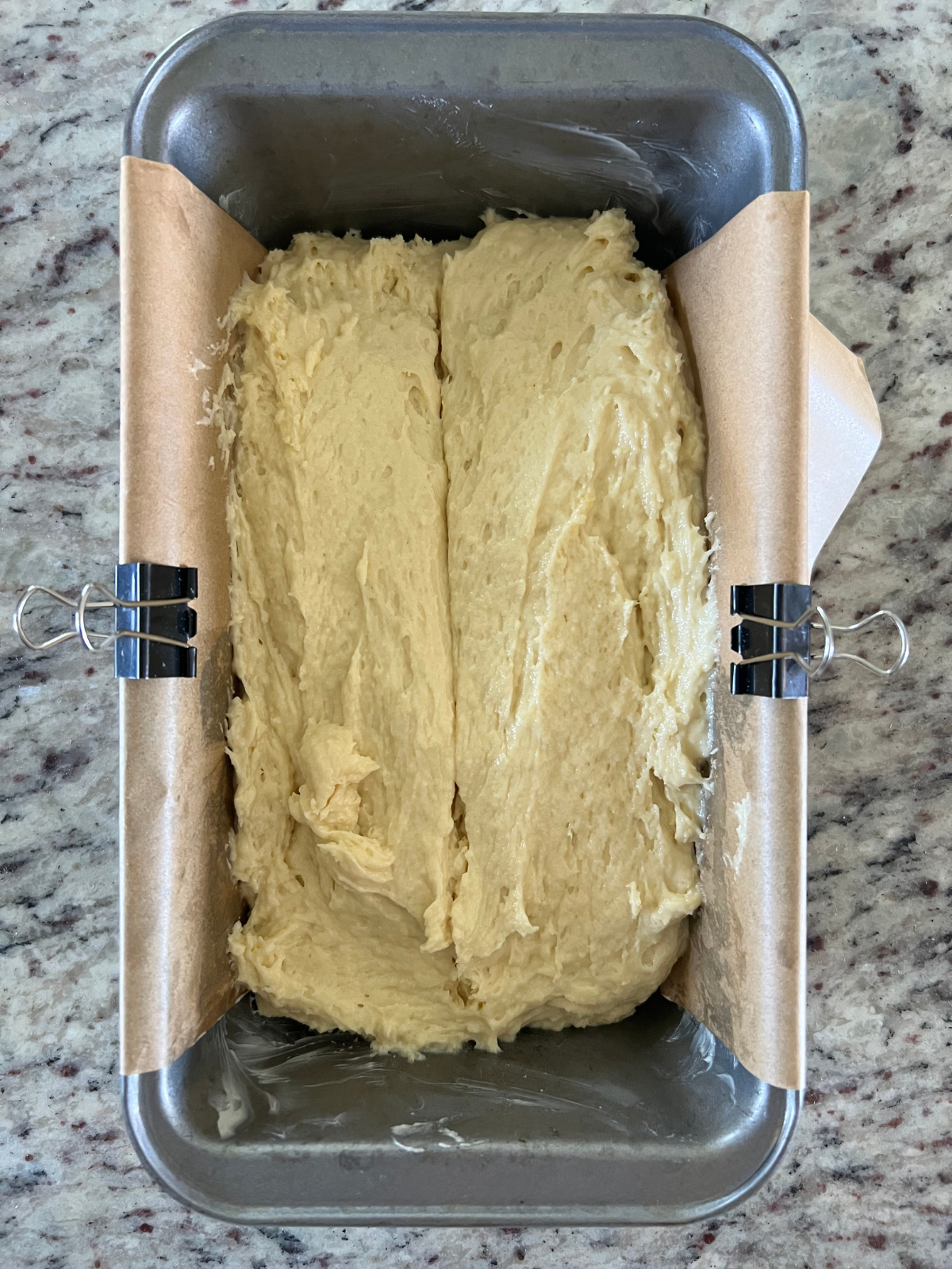 The sourdough discard vanilla pound cake batter sits in the greased and lined loaf pan.