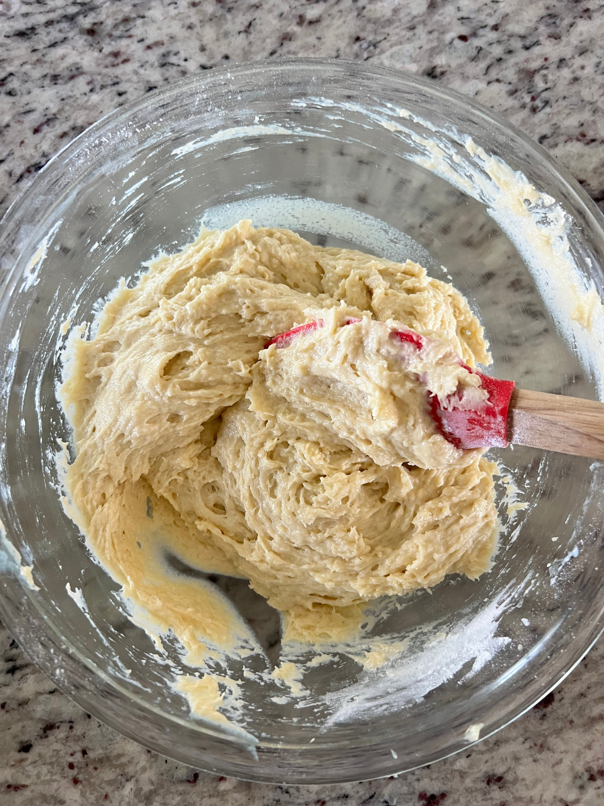 The sourdough vanilla pound cake batter is shown in a glass mixing bowl.