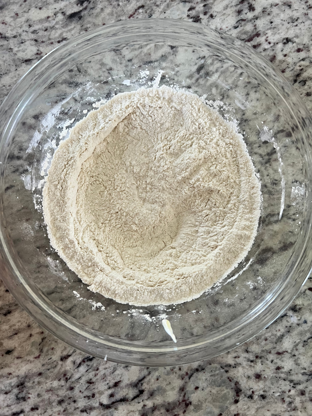 The dry ingredients for the sourdough discard vanilla pound cake sit in a glass mixing bowl.