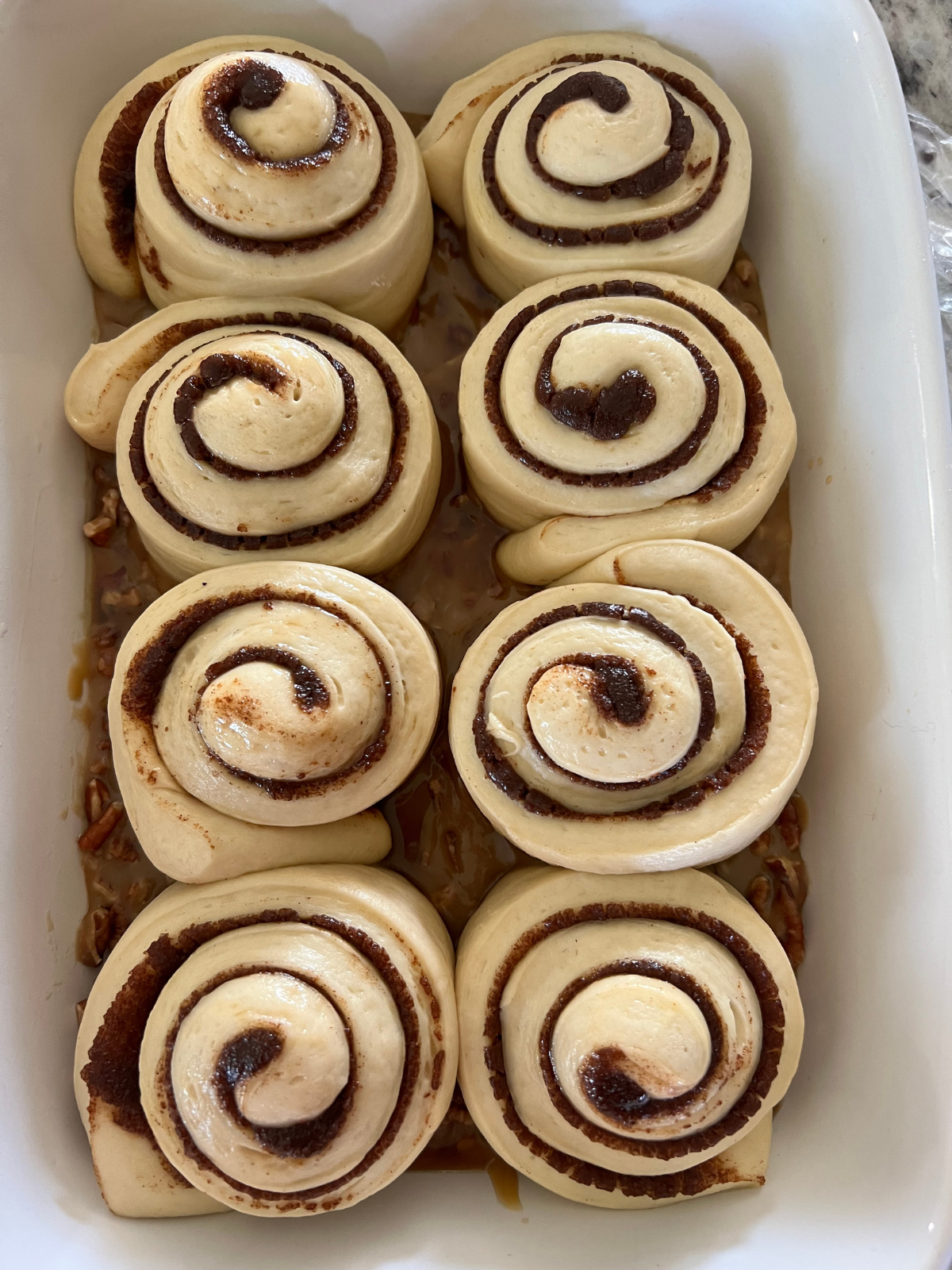 The shaped sourdough pecan sticky buns are shown after their second rise. They are noticeably puffy and now touching.