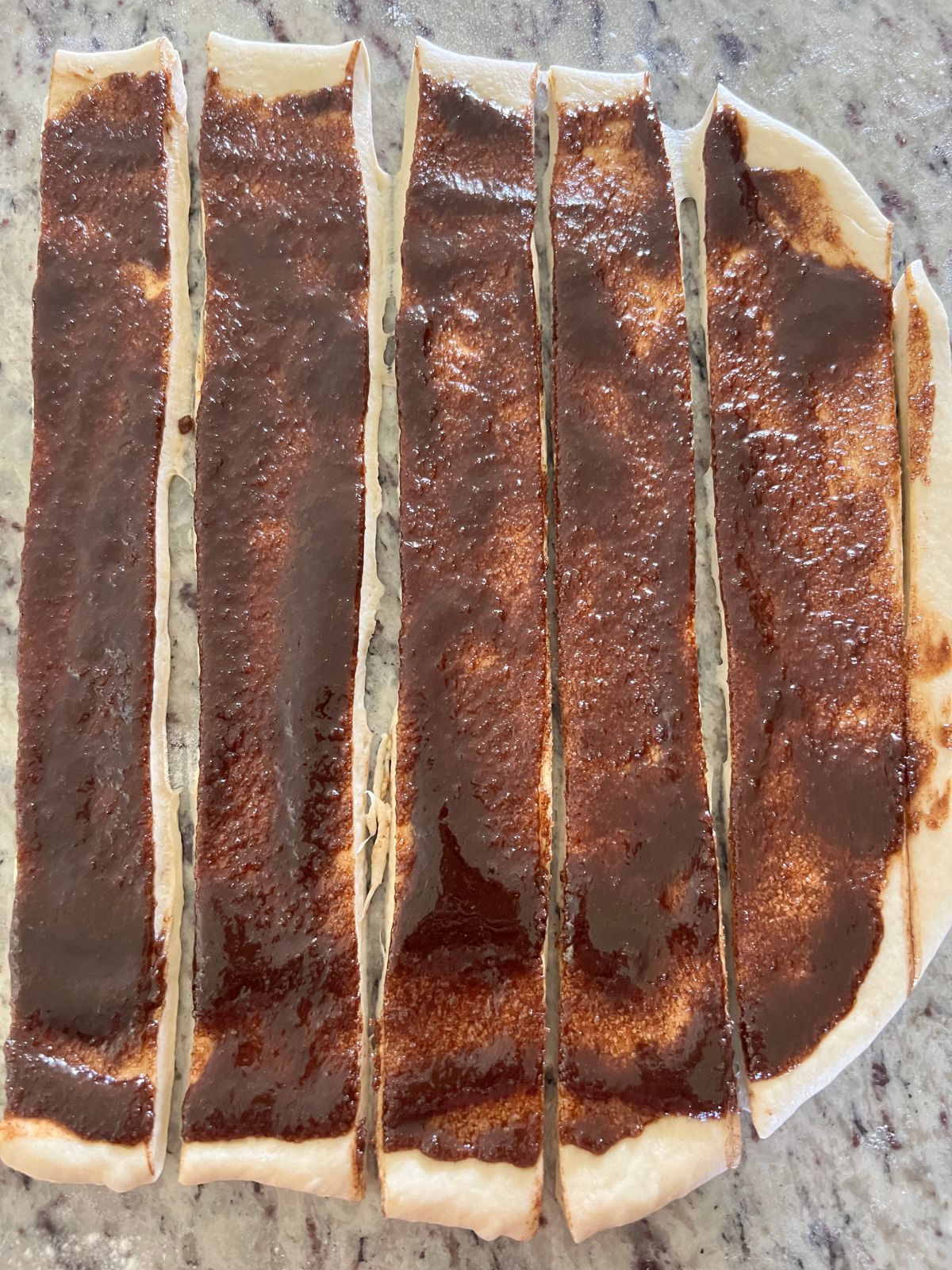 The sourdough sticky bun dough has been cut into 8 strips so they can be rolled out.