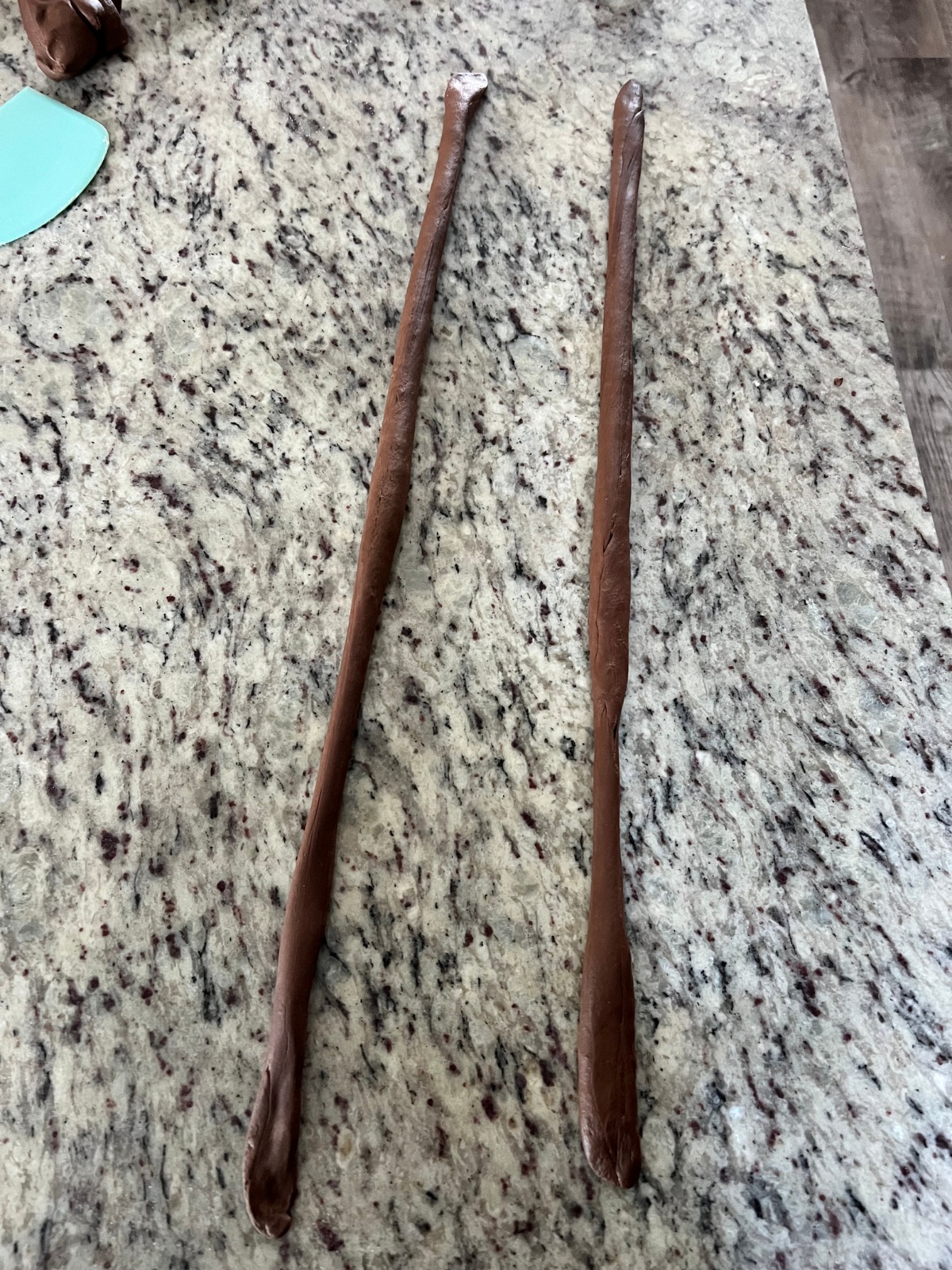 Two sourdough chocolate pretzel dough ropes are shown ready to be shaped.
