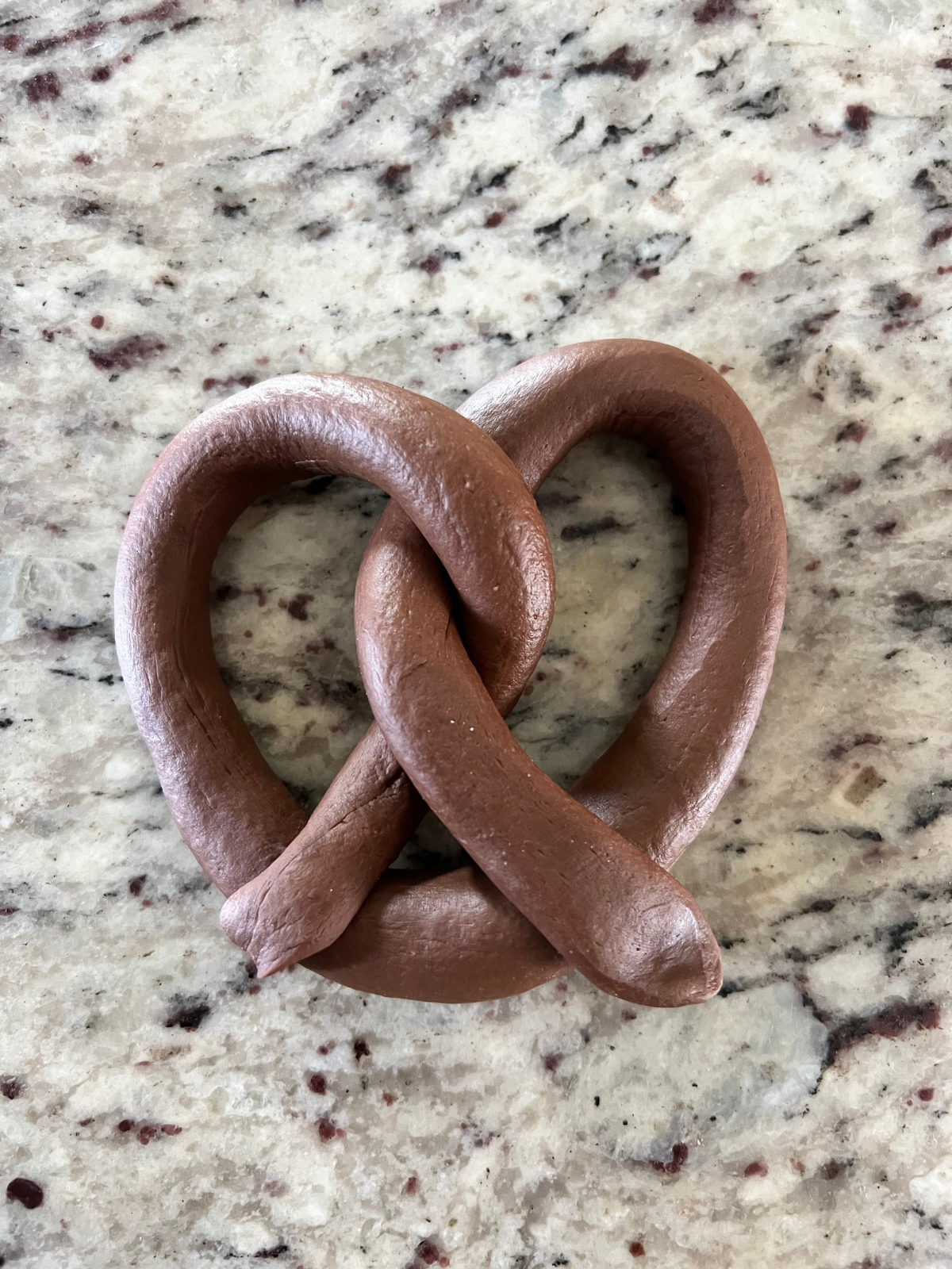 The sourdough pretzel has been shaped into a classic pretzel shape.