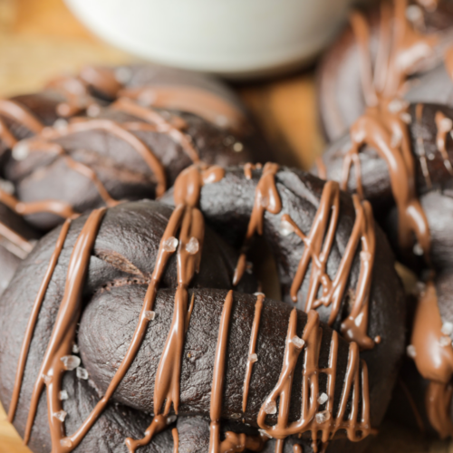 A closeup of a 100% naturally fermented sourdough chocolate pretzel with chocolate drizzled over it.