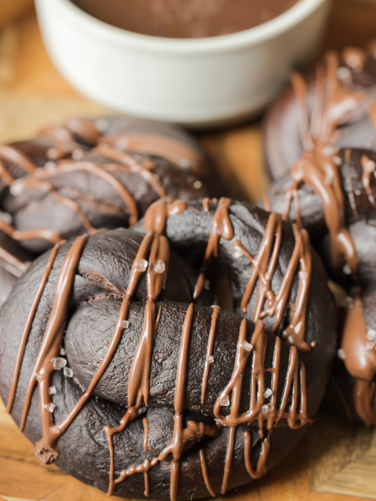 A closeup of a 100% naturally fermented sourdough chocolate pretzel with chocolate drizzled over it.