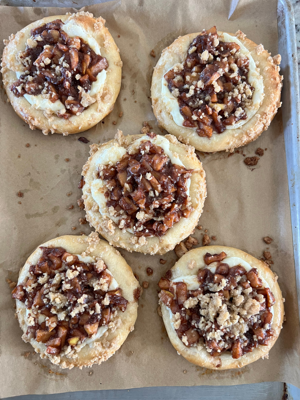 The freshly baked sourdough caramel apple kolaches are shown on the baking sheet.