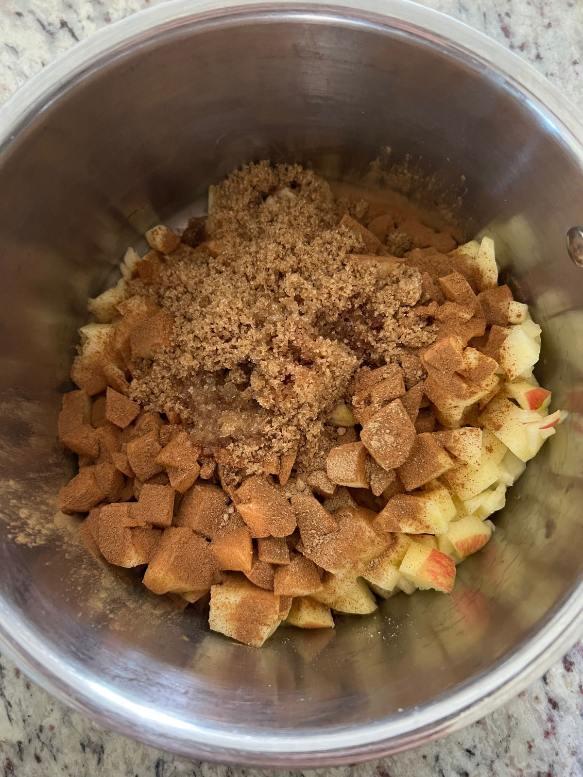 All the ingredients for the apple filling (minus the cornstarch and water slurry) sit in a saucepan preparing to cook.