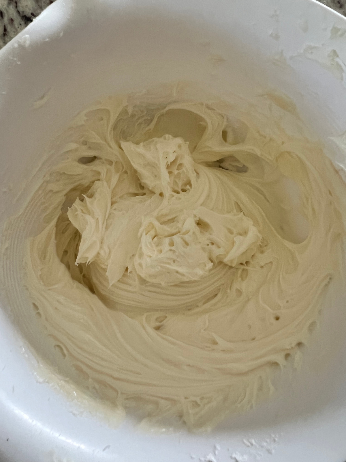 Cream cheese filling is shown in a mixing bowl after being mixed together.