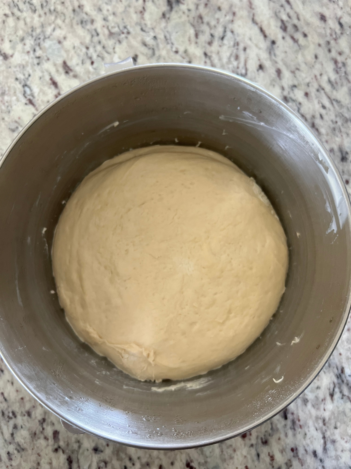 The bulk fermented sourdough brioche kolache dough is shown in the bowl of a stand mixer.