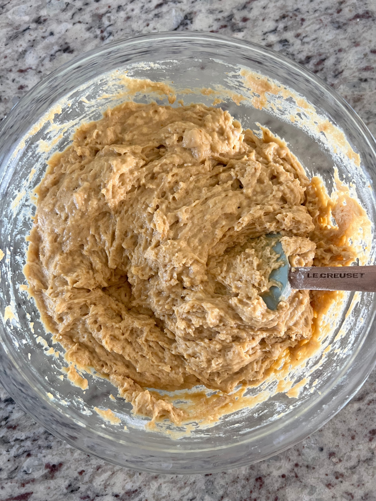 The sourdough pumpkin coffee cake batter sits in a glass mixing bowl.