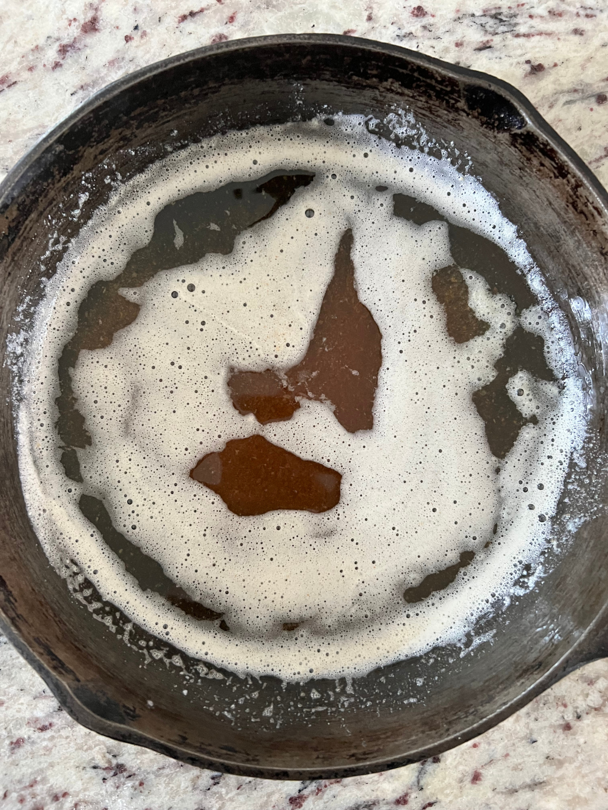 Browned butter is shown in a cast iron skillet.