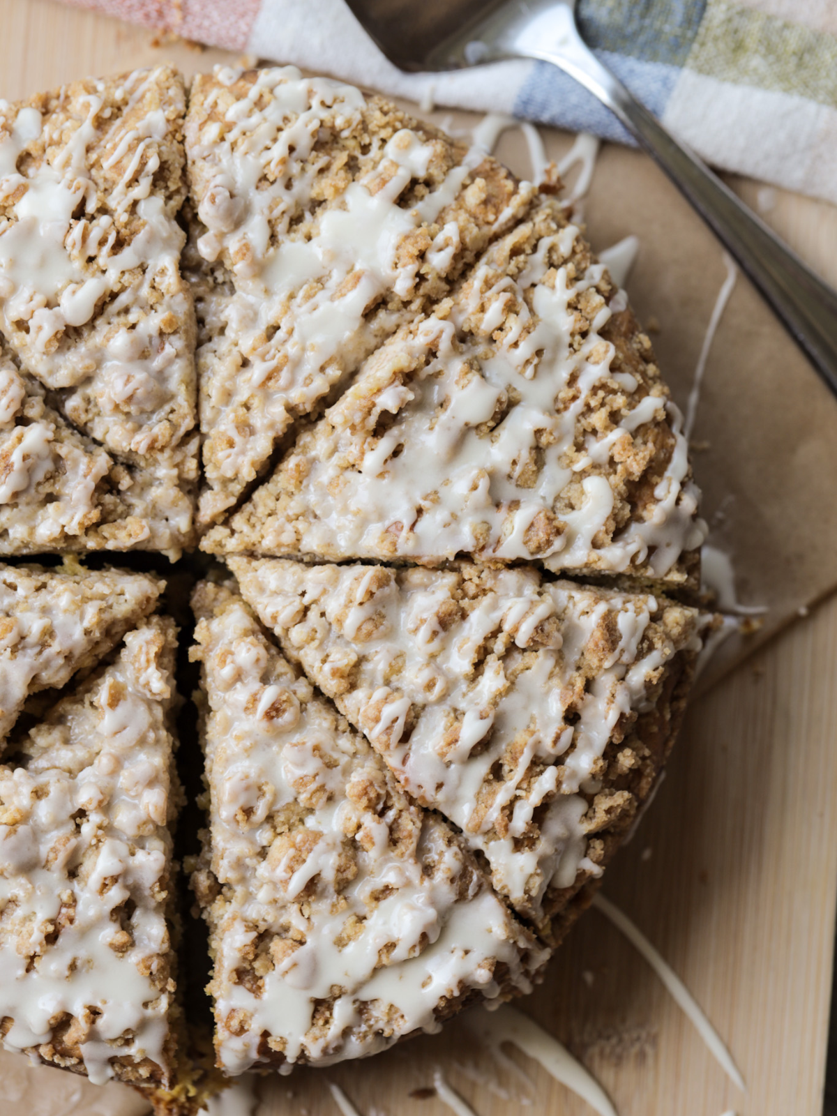 The sourdough discard pumpkin coffee cake is shown freshly baked, sliced, and drizzled with vanilla icing.