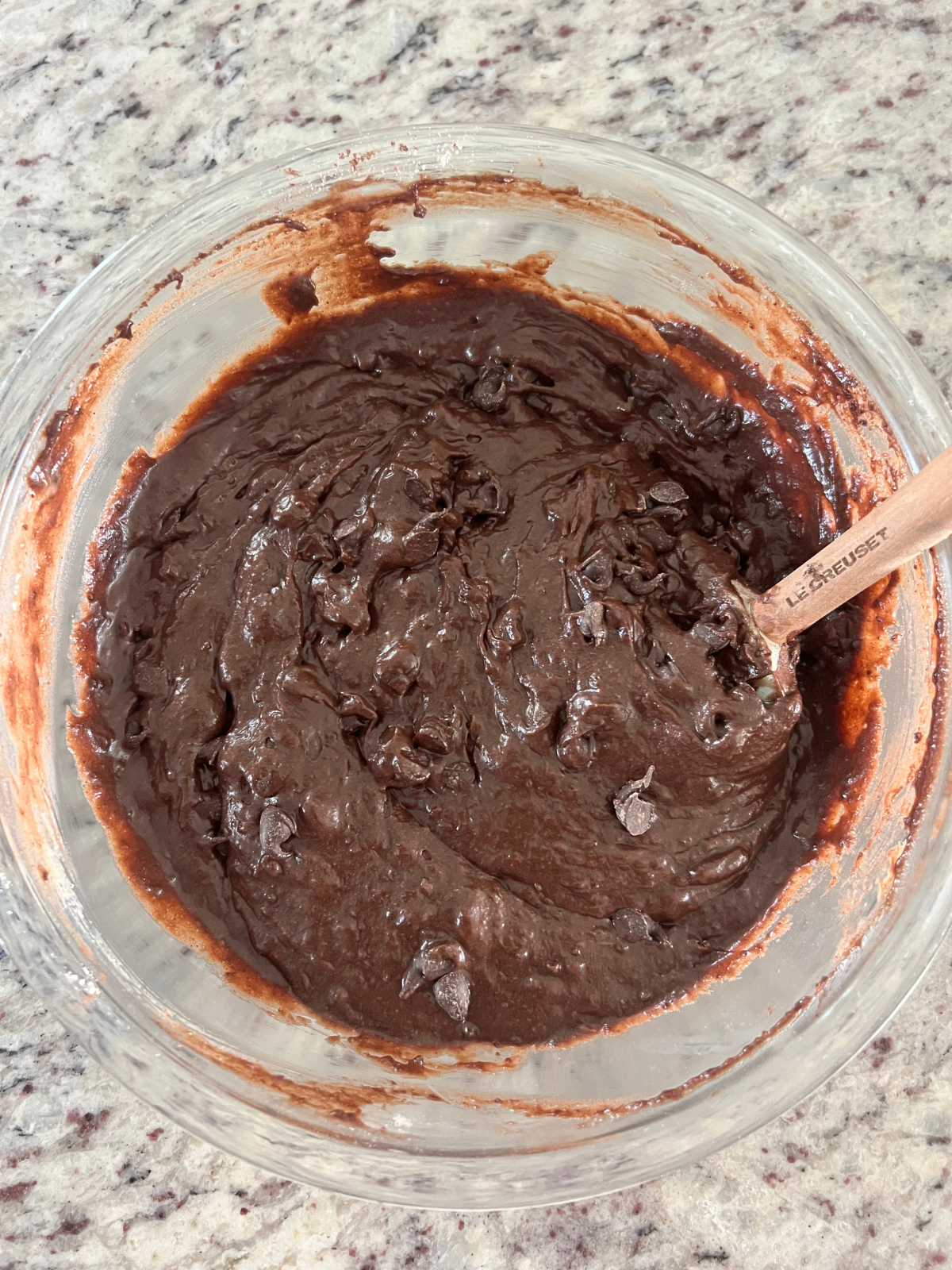 The sourdough discard brownie loaf batter sits in a glass mixing bowl. 