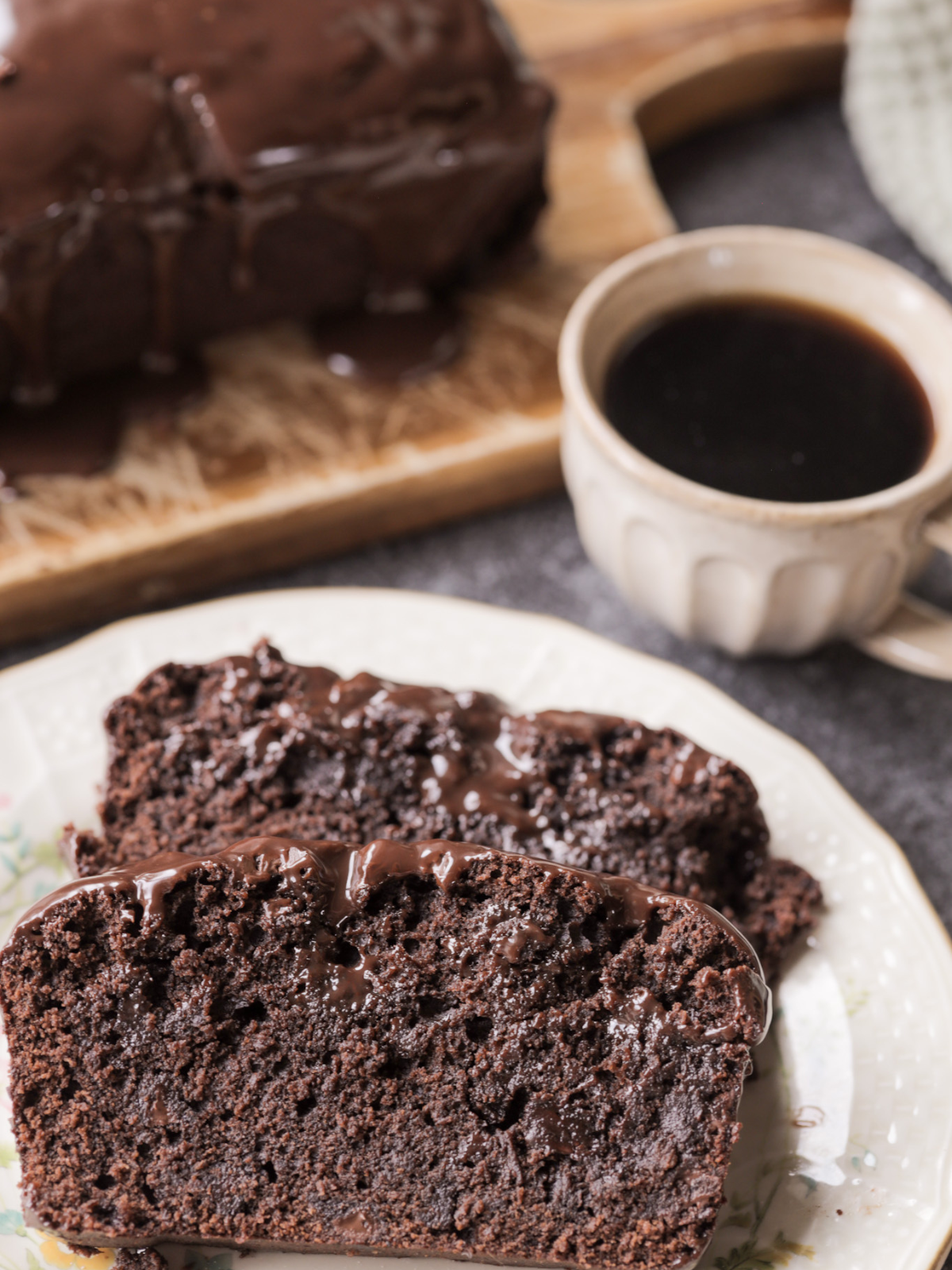 The sliced fudgy sourdough brownie bread is shown on a plate. You can see the melty chocolate, moist interior, and chocolate ganache that tops the bread.