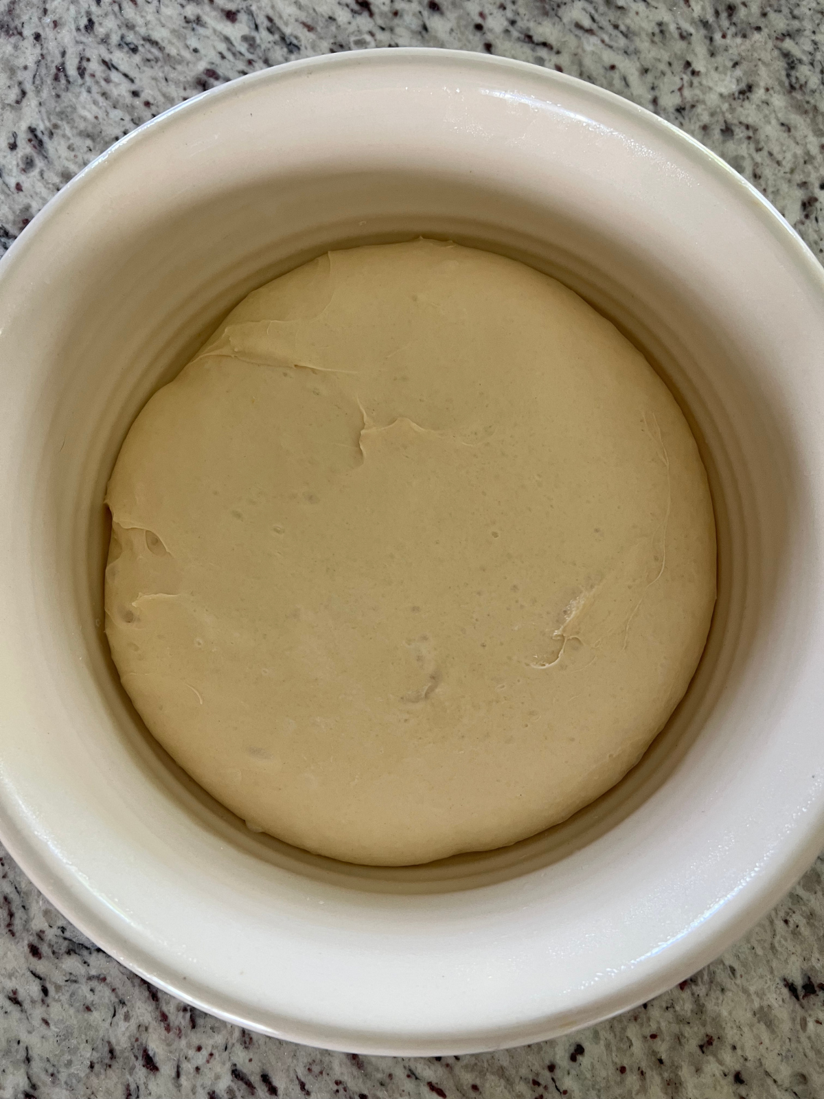 The bulk fermented sourdough maple donut dough is shown in the bowl, ready to be shaped.