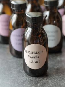 A closeup of homemade vanilla extract with many others in the background.