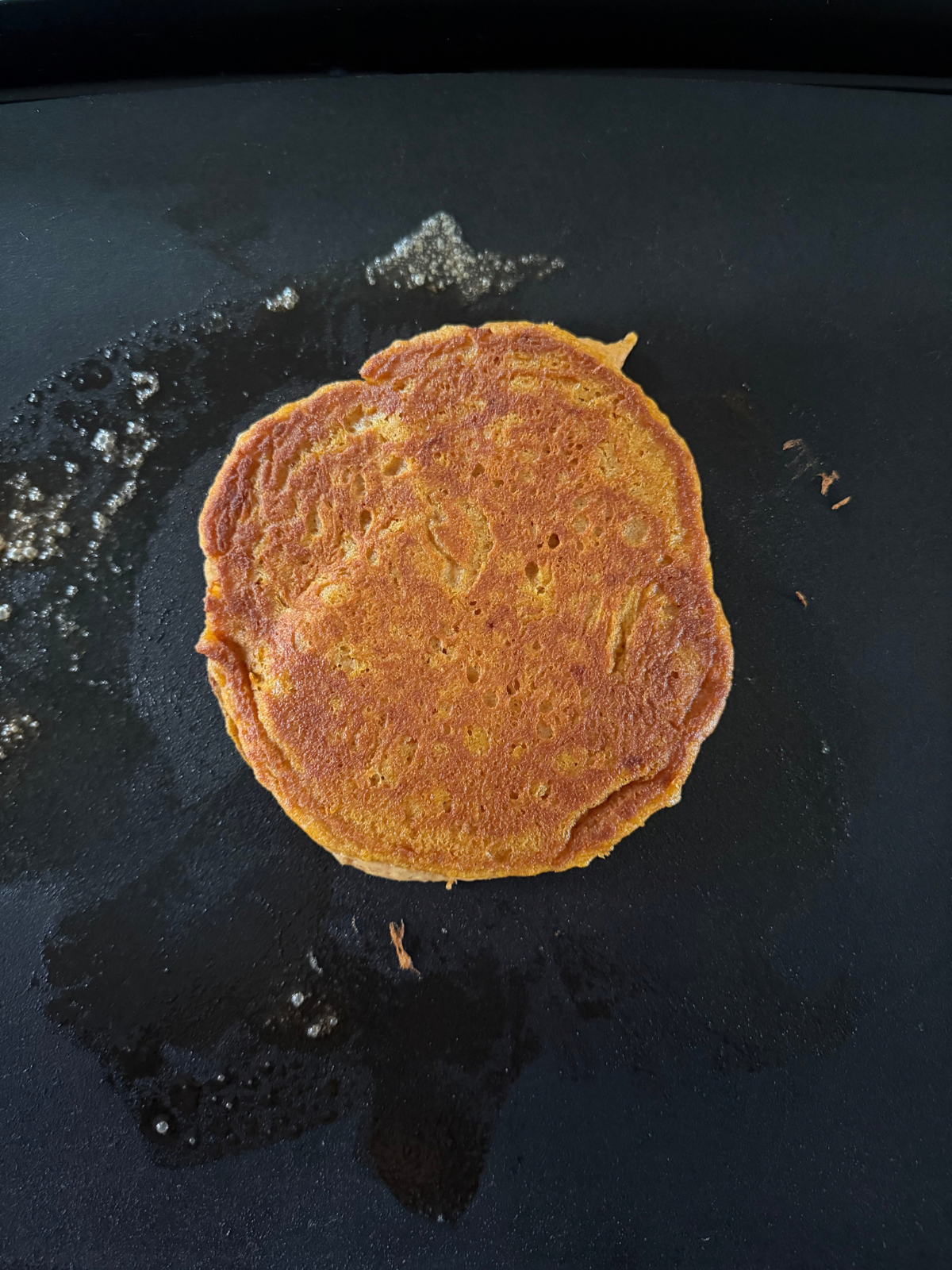 The sourdough pumpkin pancake cooks on the griddle.
