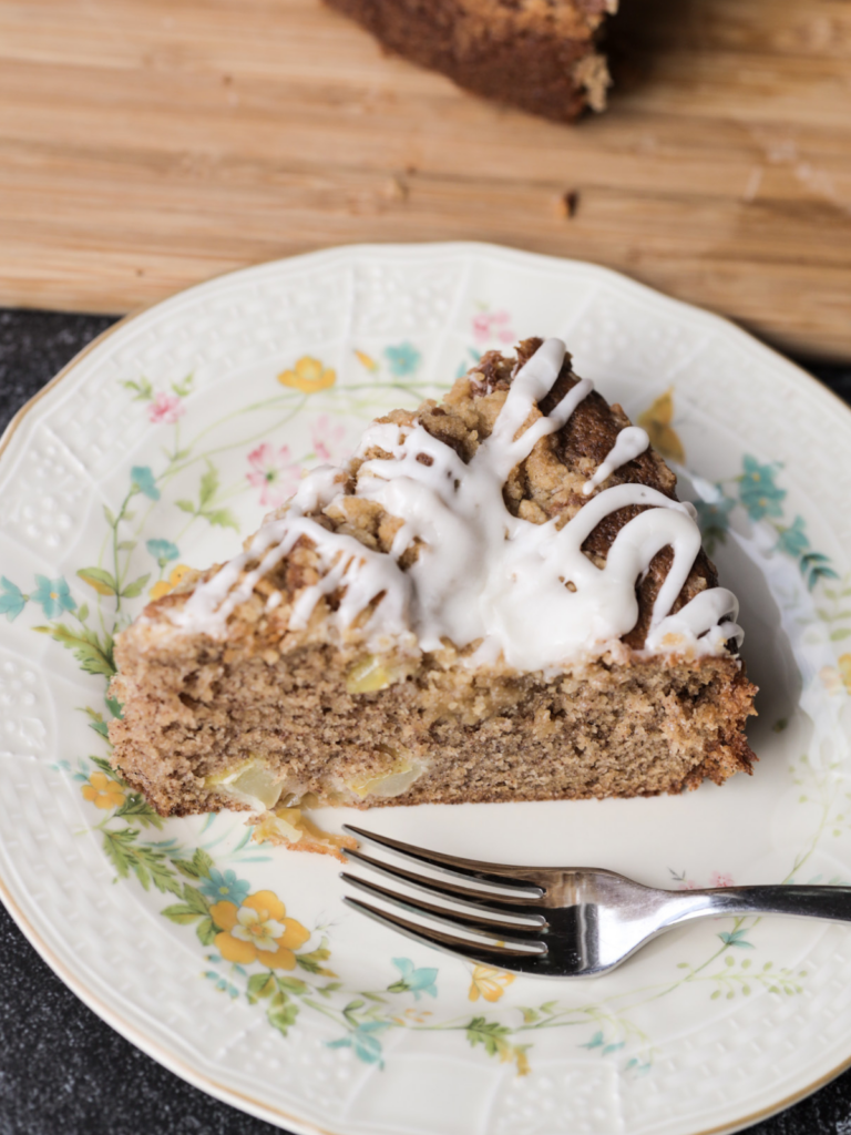 A slice of sourdough discard brown butter apple streusel coffee cake sits on a floral plate.