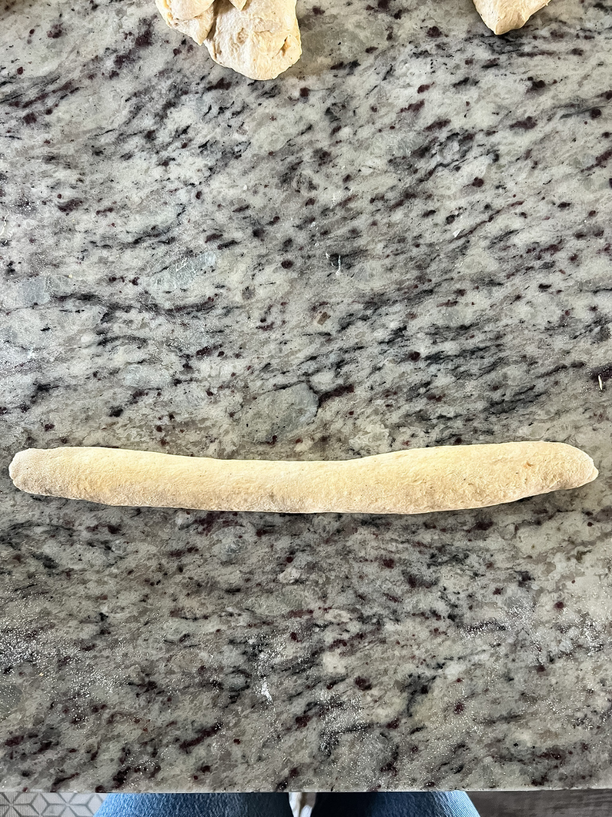 The dough has been pinched and sealed together and rolled into a rope about 8 inches in length.