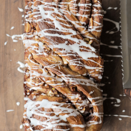 A loaf of sourdough apple-filled babka with vanilla icing drizzled over the top. This sourdough brioche dough is 100% naturally leavened--no yeast!