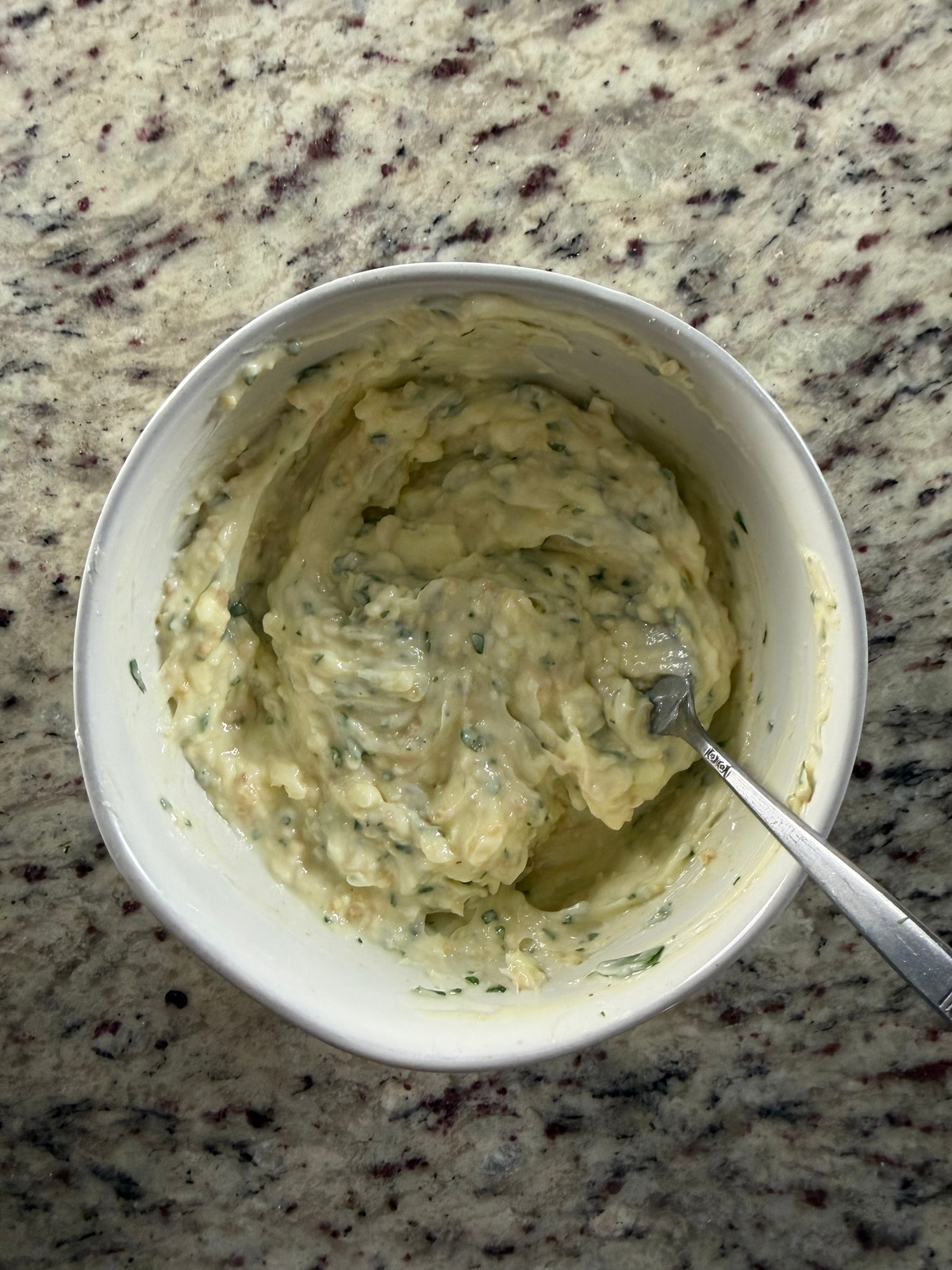 Garlic herb butter is shown in a bowl.